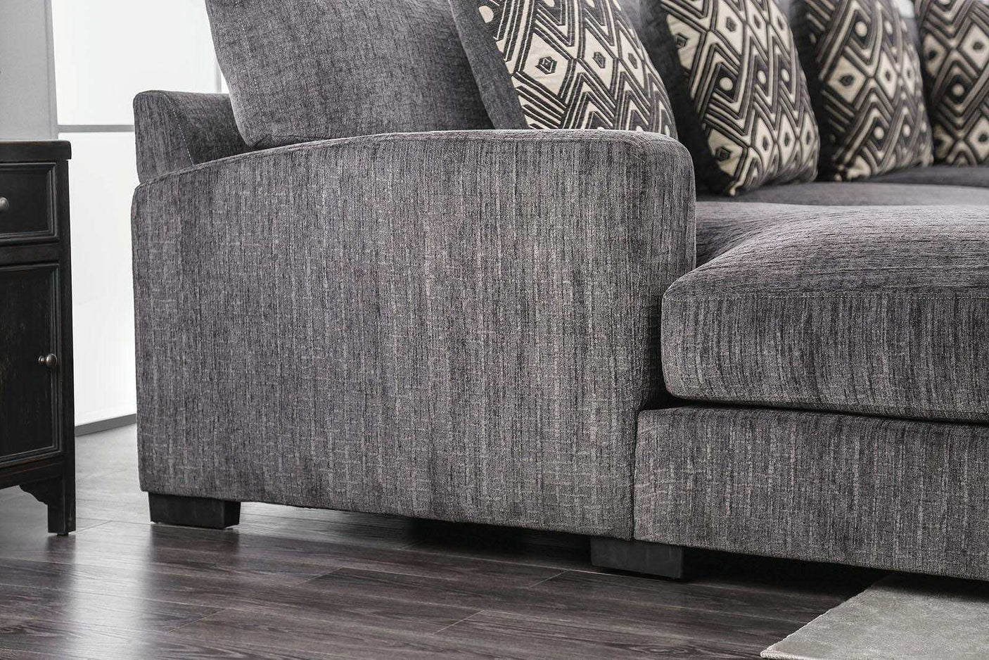 Gray sofa with patterned cushions on a wooden floor