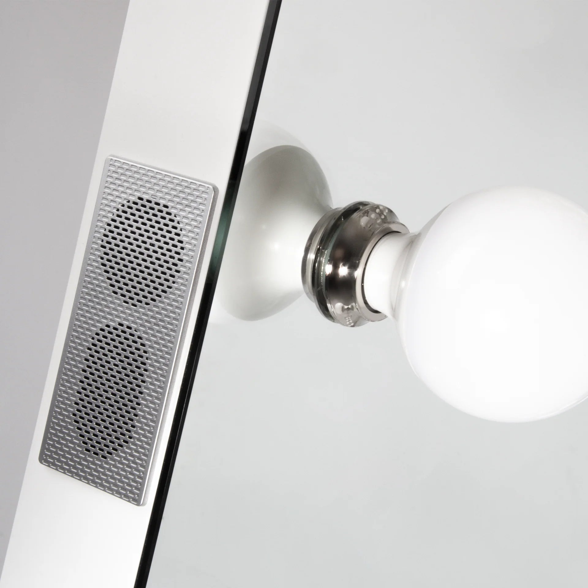 Close-up of a modern wall-mounted light fixture with a speaker on a gray background