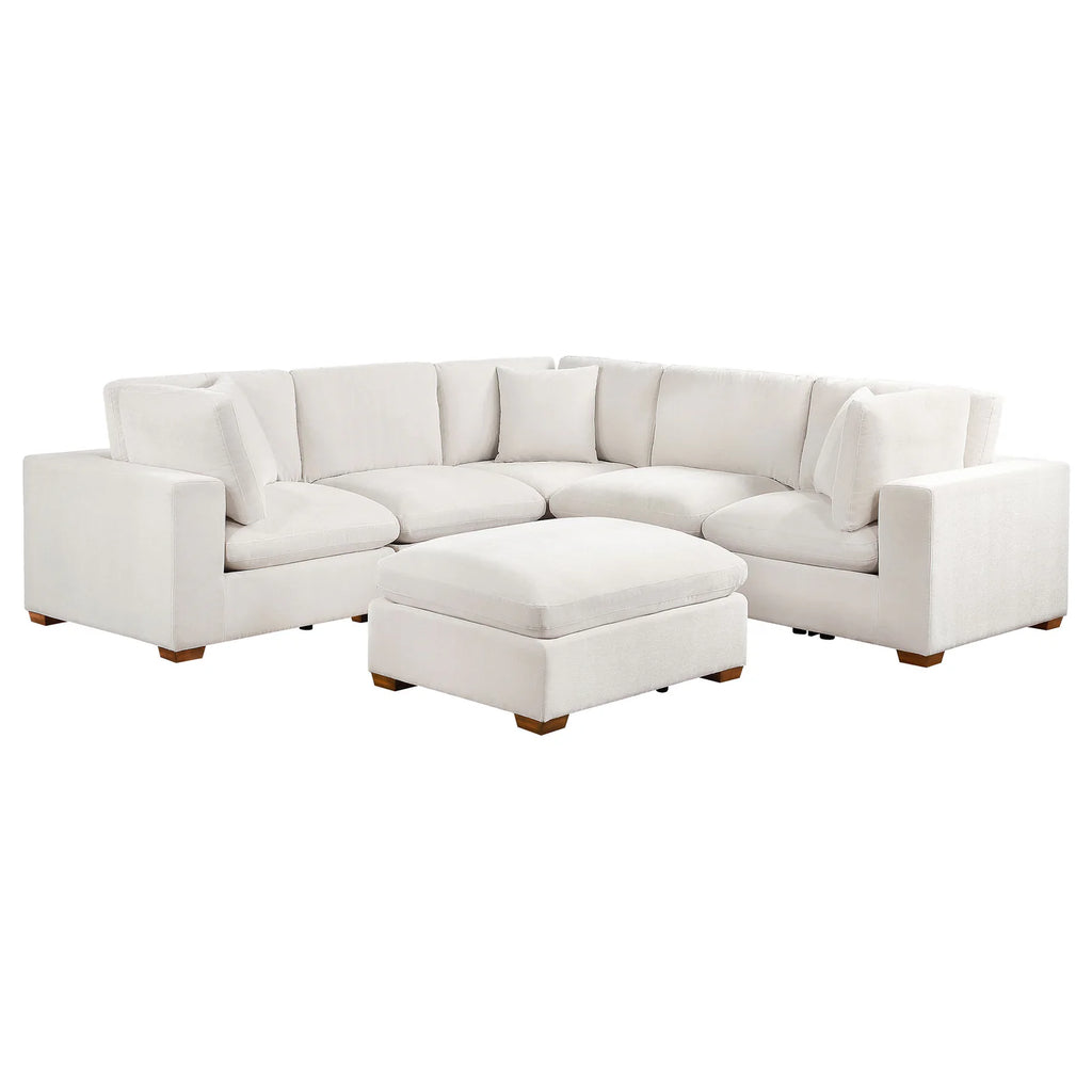 Ivory sectional sofa with ottoman on a white background