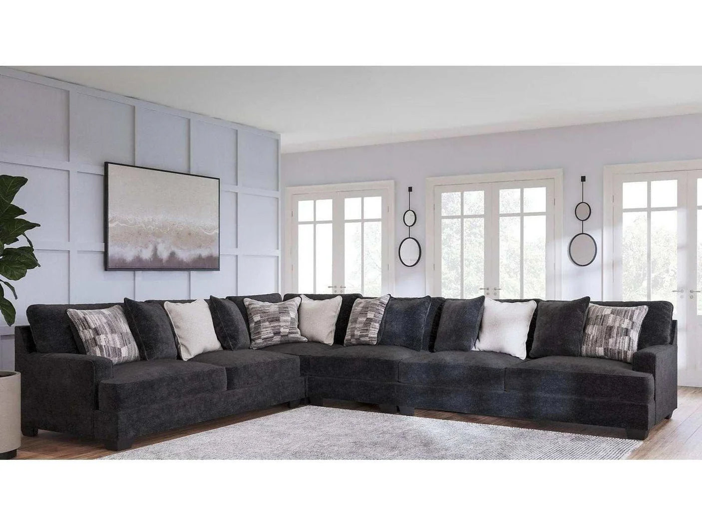 Gray charcoal sectional sofa in a living room with decorative pillows and a wall art piece.