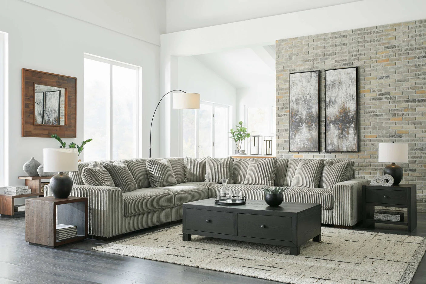 Modern living room with a gray sectional sofa, coffee table, and decorative elements.