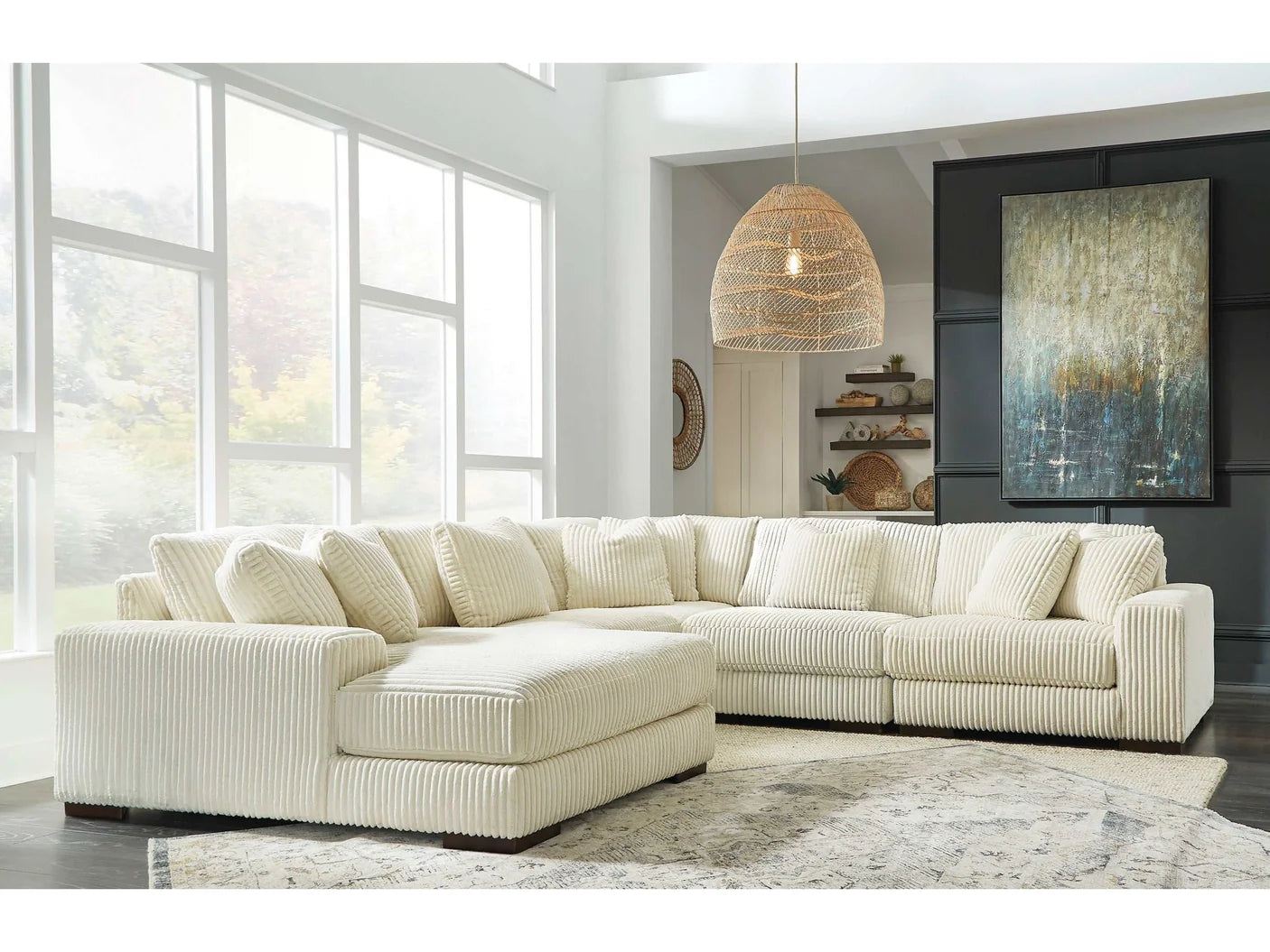 Beige sectional sofa in a modern living room with large windows and decorative elements.