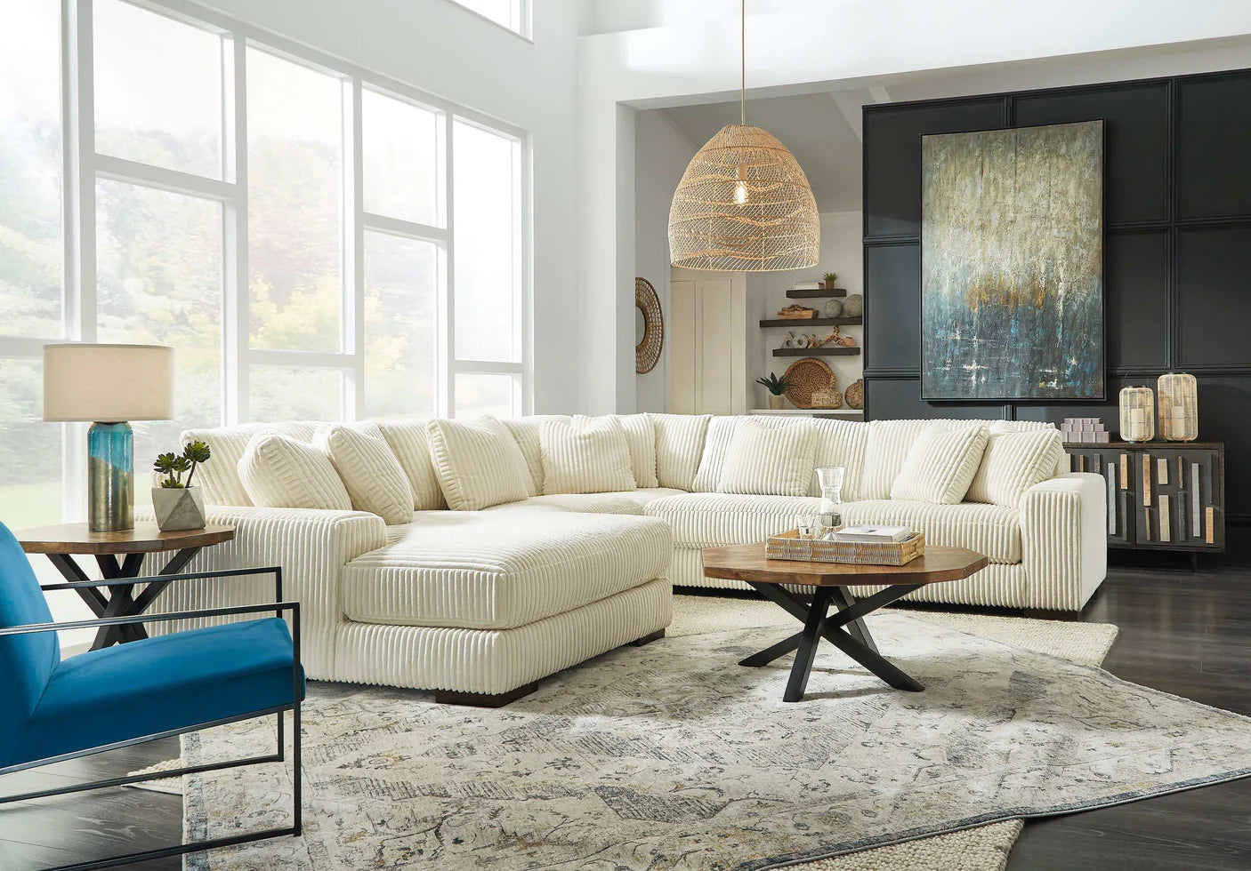 Modern living room with a beige sectional sofa, blue chair, and decorative elements.