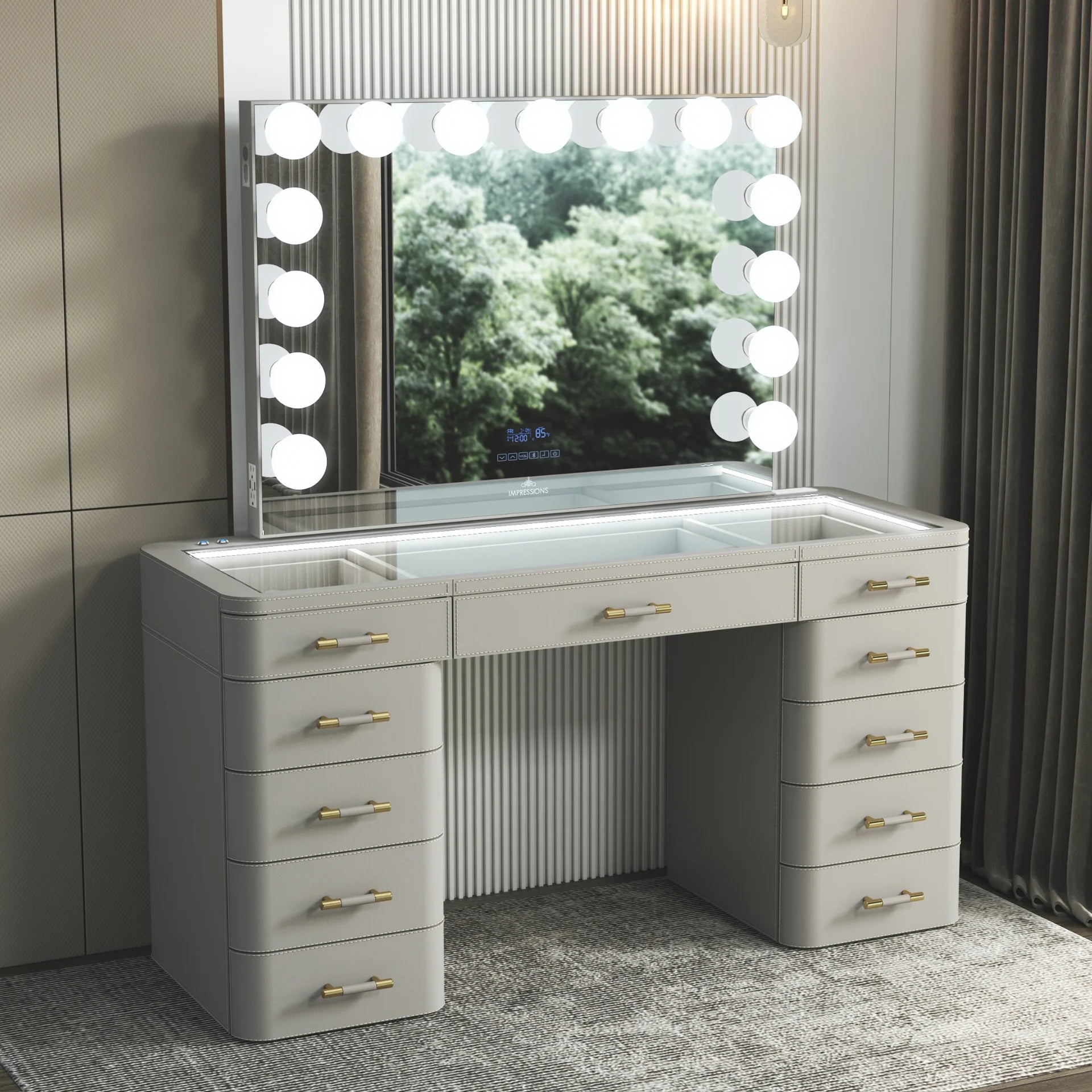 Luxury light gray makeup vanity set with illuminated Hollywood mirror, glass top storage compartments, LED lighting, and gold drawer handles in a modern bedroom.