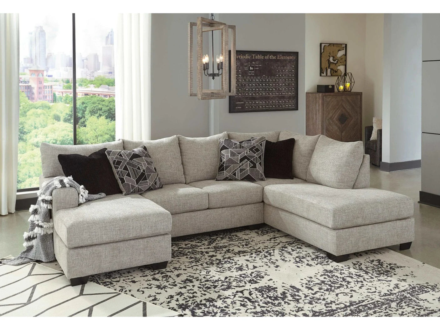 Gray sectional sofa in a living room with large windows and decorative elements.