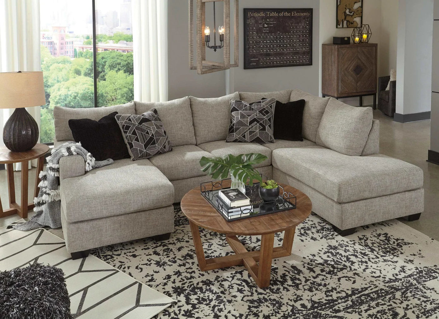 Living room with a gray sectional sofa, wooden coffee table, and decorative elements.