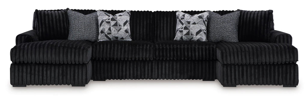 Black ribbed sectional sofa with patterned cushions on a white background