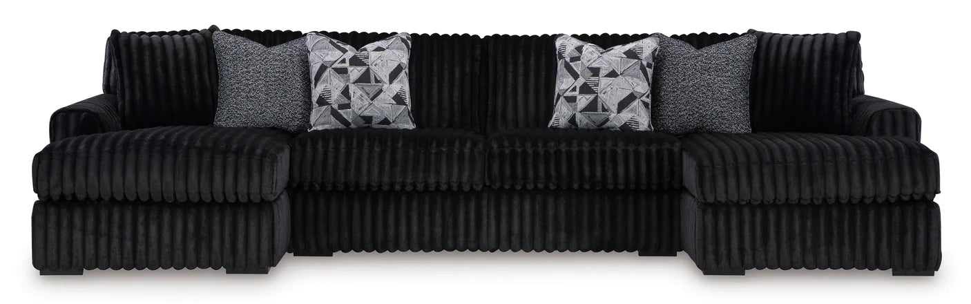 Black ribbed sectional sofa with patterned cushions on a white background