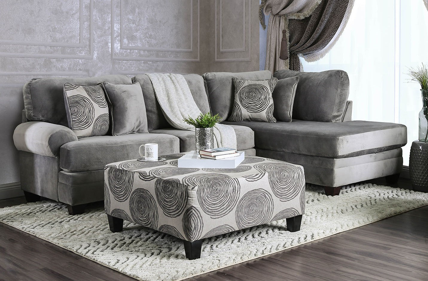 Gray sectional sofa with matching ottoman in a living room setting.