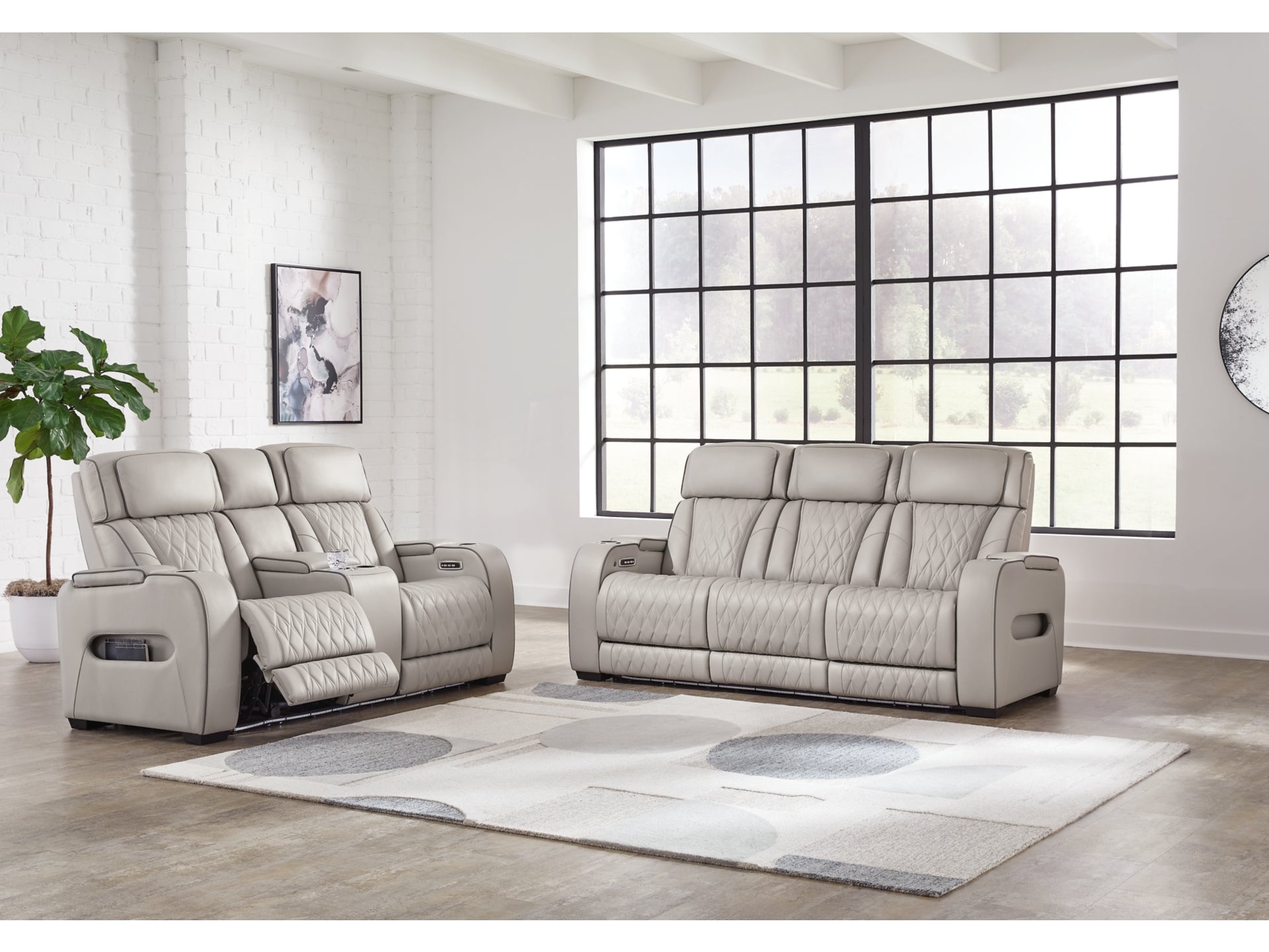 Gray recliner sofa set in a modern living room with large windows.