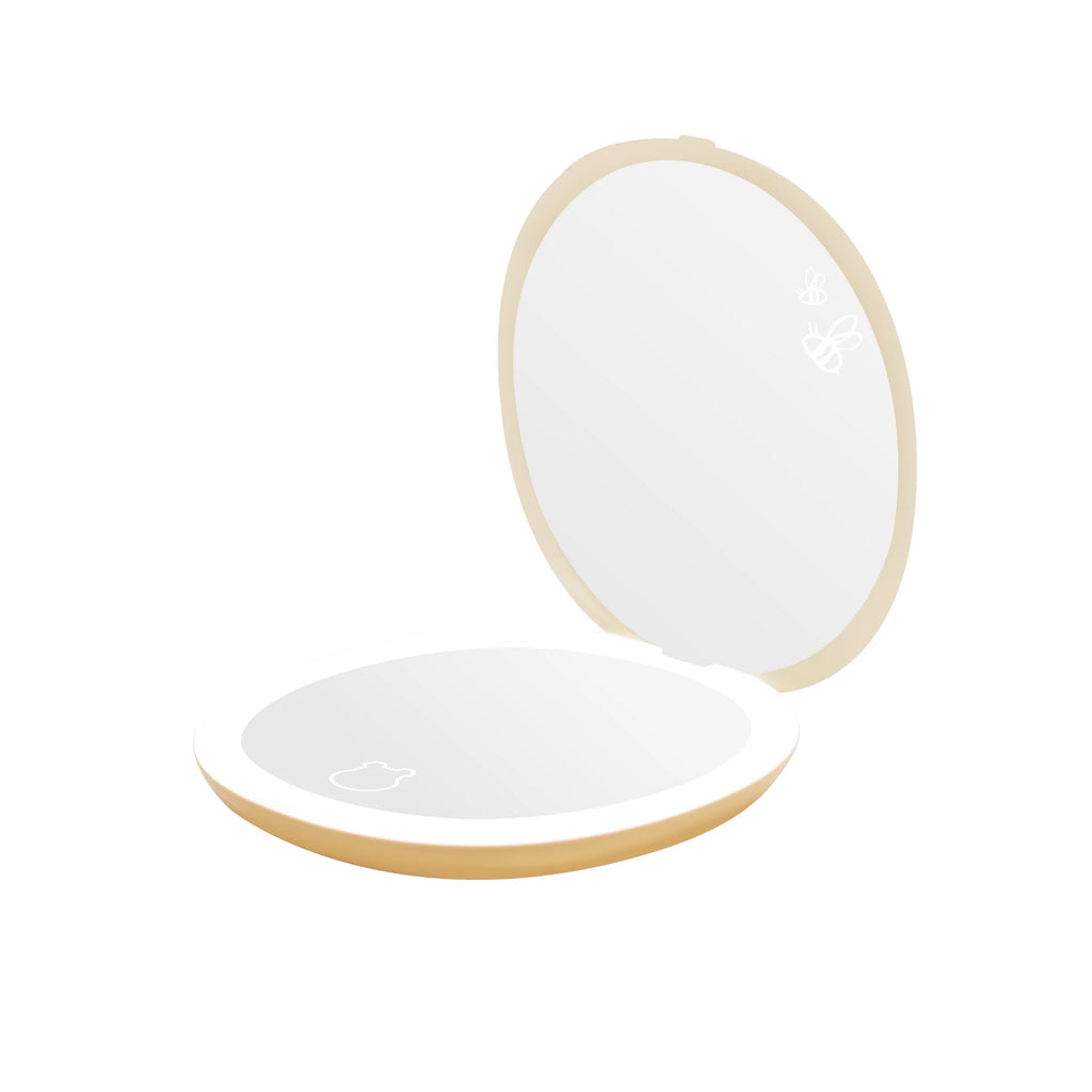 Round, light-colored makeup mirror with a white interior on a white background