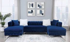 Blue sectional sofa in a living room with decorative wall art and plants.