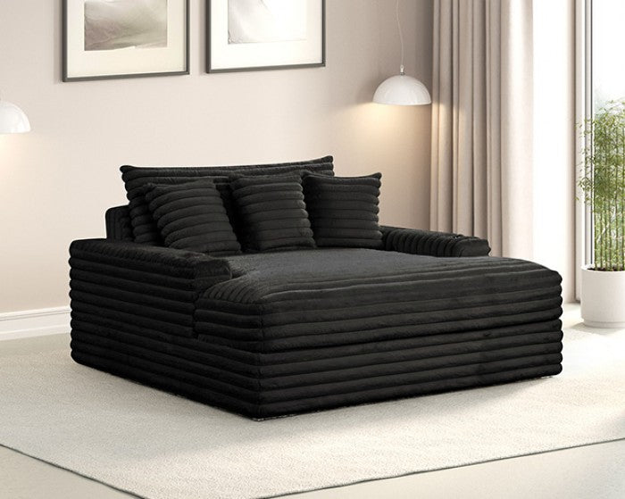 Black sofa chaise in a living room setting with framed pictures on the wall.