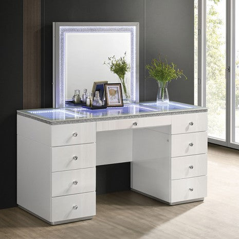 White vanity desk with mirror and decorative items in a room with large windows.