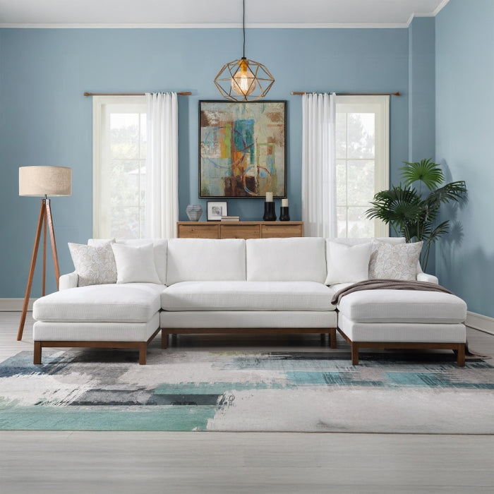 Modern living room with a white sectional sofa, blue walls, and decorative elements.