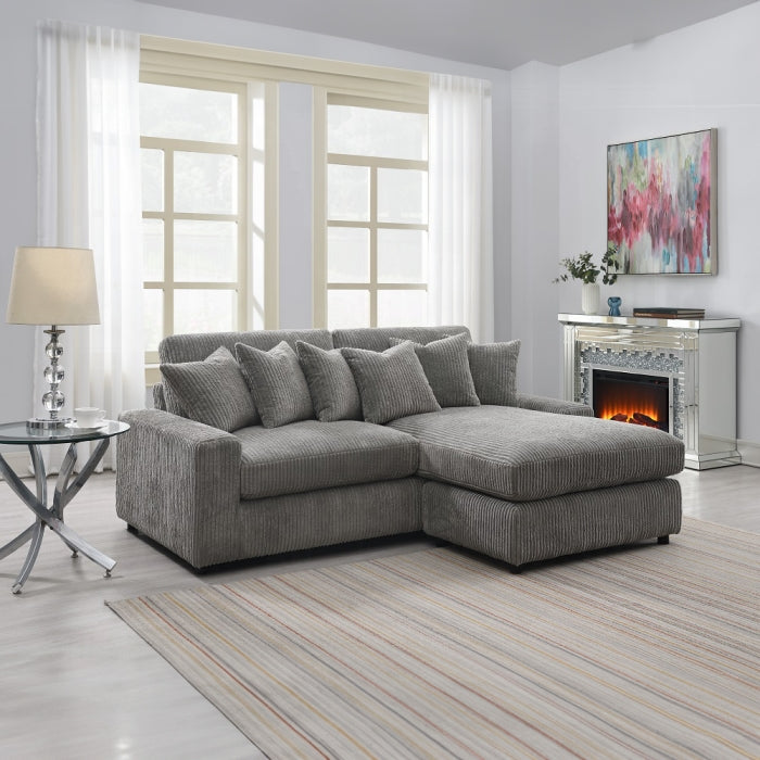 Gray sectional sofa in a living room with a fireplace and decorative elements.