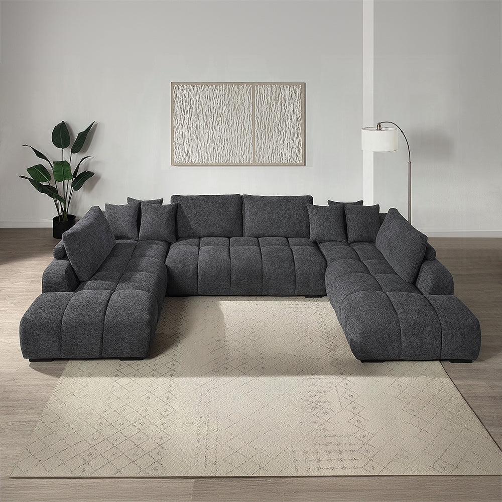 Gray sectional sofa in a living room setting with a plant and lamp.