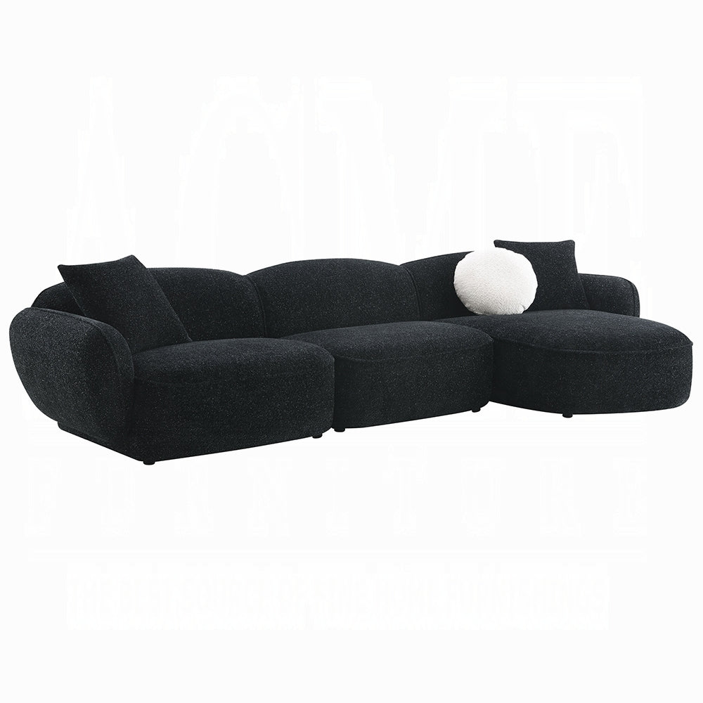 Black sectional sofa with a white pillow on a white background