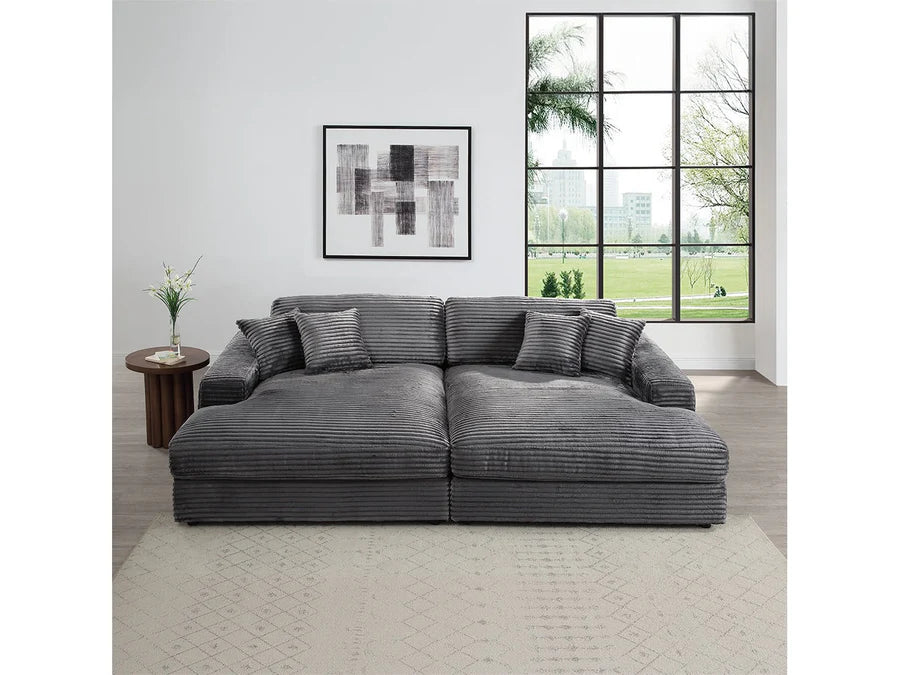 Gray sectional sofa in a living room with a large window and abstract art on the wall.