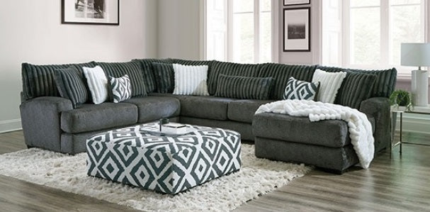 Gray sectional sofa with patterned ottoman in a living room setting